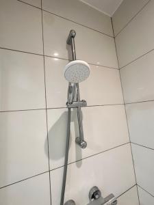 a shower with a shower head in a bathroom at Double and single rooms in Bromley by bow in London