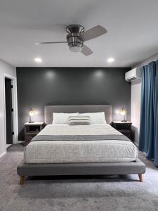 Veda Inn & Cottages في ماجي فالي: غرفة نوم بسرير ومروحة سقف