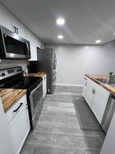 Veda Inn & Cottages في ماجي فالي: مطبخ بدولاب أبيض وأجهزة سوداء