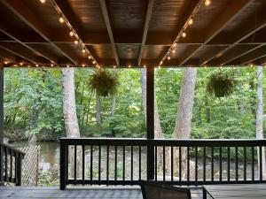 a porch with a view of a river and trees at Veda Inn & Cottages in Maggie Valley