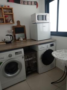 uma cozinha com 2 máquinas de lavar roupa e um micro-ondas em NEW! Great Location! Vibrant Downtown, Talpiot Market, Flea Market, Carmel Beach, close to everywhere em Haifa