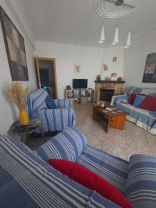 a living room with a couch and chairs and a fireplace at Fred E Kika Holidays in Portimão