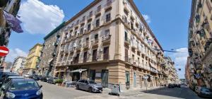 a large building on a city street with cars parked on the street at Appartamento B&B La Dimora di Parthenope in Naples