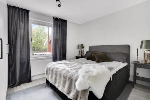 a white bedroom with a large bed with a window at Beautiful apartment minutes away from ski slopes in Järvsö