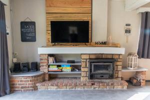 a fireplace with a television on top of it at Au Repos de la Redoute in Aywaille