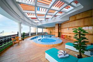 فندق رتاج الريان في الدوحة: مسبح داخلي كبير في مبنى به سقف