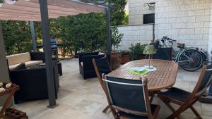 una mesa de madera y sillas en un patio en Apulia Home, en Zapponeta