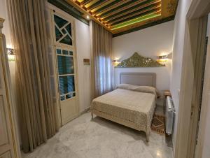 a small bedroom with a bed and a window at Dar Hamouda Guest House - Médina de Tunis in Tunis