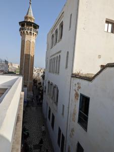 Dar Hamouda Guest House - Médina de Tunis في تونس: مبنى فيه برج ساعة بجانب مبنى