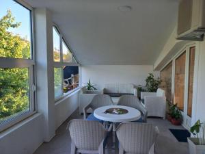 a room with a table and chairs and windows at Vila Nastovski in Veles