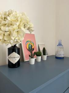 una mesa con un jarrón con flores y una foto en 10 MAGGIO APARTMENTS, en Augusta