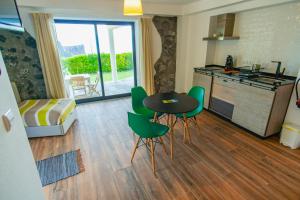 a kitchen with a table and green chairs in a room at Casa dos Lagos - RRAL nº 2187 in Velas