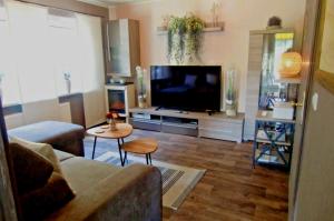 a living room with a couch and a flat screen tv at Ferienwohnung Heideschwedin in Eschede
