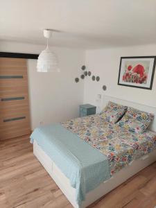 ein Schlafzimmer mit einem Bett mit einer bunten Bettdecke in der Unterkunft Les hirondelles in Laquenexy