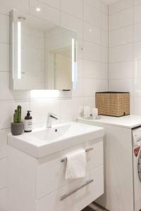 Baño blanco con lavabo y espejo en Dinbnb Apartments I Luxury with Views & Parking en Bergen