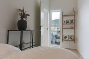 1 dormitorio con 1 cama y un jarrón en un estante en Dinbnb Apartments I Luxury with Views & Parking en Bergen
