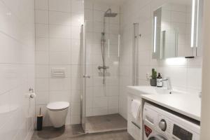y baño con ducha, aseo y lavamanos. en Dinbnb Apartments I Luxury with Views & Parking en Bergen