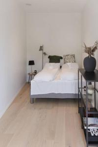 1 dormitorio con cama blanca y suelo de madera en Dinbnb Apartments I Luxury with Views & Parking en Bergen