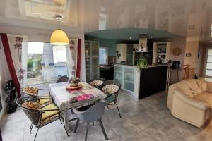 Maison Kermajo في Plougastel-Daoulas: مطبخ وغرفة معيشة مع طاولة وكراسي