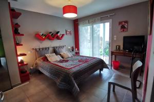 Maison Kermajo في Plougastel-Daoulas: غرفة نوم مع سرير مع حذاء احمر على الحائط