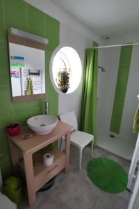 Un baño verde con lavabo y espejo. en Maison Kermajo, en Plougastel-Daoulas 9 fotos más