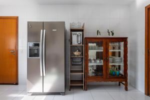 a kitchen with a stainless steel refrigerator and a cabinet at Casa incrível com 04 suítes - 5 min de Itacoatiara in Niterói