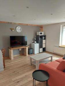 ein Wohnzimmer mit einem roten Sofa und einem Tisch in der Unterkunft Les hirondelles in Laquenexy