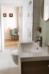 a bathroom with a sink and a toilet and a mirror at Wohlfühloase im Herzen von Wiedenbrück in Rheda-Wiedenbrück