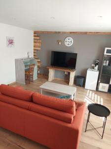 ein Wohnzimmer mit einem roten Sofa und einem Tisch in der Unterkunft Les hirondelles in Laquenexy