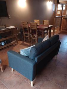sala de estar con sofá azul y mesa en Departamentos turismo en San Martín de los Andes