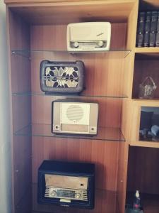 a book shelf with three boxes and a radio at The Little Blooming House in Agíasma
