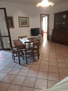 - un salon avec une table, des chaises et une télévision dans l'établissement Casa Rachele, à Martinsicuro