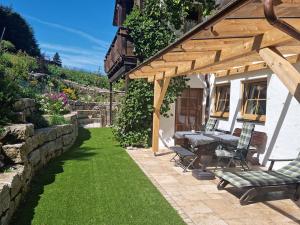 un patio con una mesa y sillas en el césped en Villa im Wald, en Rosshaupten