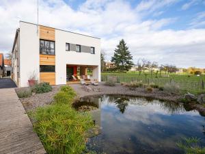 a house with a pond in front of it at La Maison Devant La Prairie Contact O66I4O9II9 in Griesheim-près-Molsheim