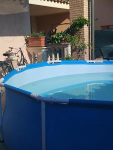 una grande vasca blu seduta accanto a una casa di La Baia Dei Delfini ad Ardea