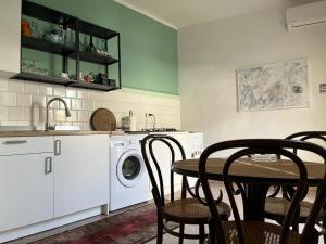 a kitchen with a washing machine and a table with chairs at Casa Giagantini in Scicli