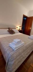 a bedroom with two beds with white towels on it at Il sole in Carpi