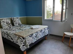 Un dormitorio con una cama en una habitación con ventana. en Villa au calme proche plage de Fabregas, en La Seyne-sur-Mer