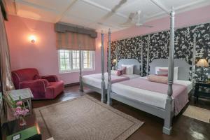 Bopitiya的住宿－Taylor's Hill，一间卧室配有两张床、一把椅子和一张沙发