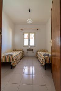 Habitación con 2 camas y ventana en Casa vacanze Ogliastra, en Girasole
