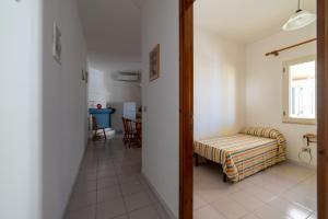 Un pasillo con una habitación con una cama y una mesa en Casa vacanze Ogliastra, en Girasole