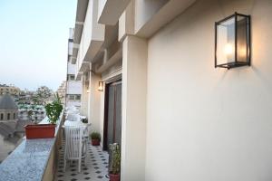 a balcony with white chairs and a light on the side of a building at Eileen Hotel Cairo in Cairo