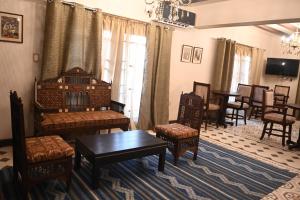 een woonkamer met stoelen, een bank en een tafel bij Eileen Hotel Cairo in Caïro