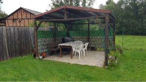 een houten prieel met een tafel en stoelen in een tuin bij Ferienwohnung Wippertal Biesenrode in Mansfeld