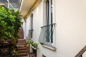 un callejón de un edificio con escaleras y ventanas en Neró Rooms, en Taormina