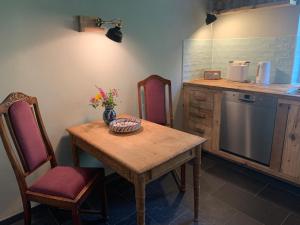 a kitchen with a wooden table and chairs and a counter at Alter Südhof in Borstel