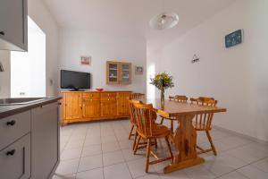cocina con mesa de madera con sillas y TV en Casa vacanze Ogliastra, en Girasole