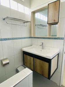 ein Badezimmer mit einem Waschbecken, einem Spiegel und einem WC in der Unterkunft เกรซรูม รีสอร์ท (Grace Room Resort) 
