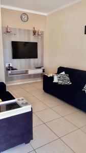 a living room with a couch and a flat screen tv at RANCHO KWILL in Serra Negra