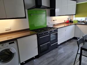 a kitchen with a stove and a washing machine at Ballintoy house with great sea views in Ballintoy